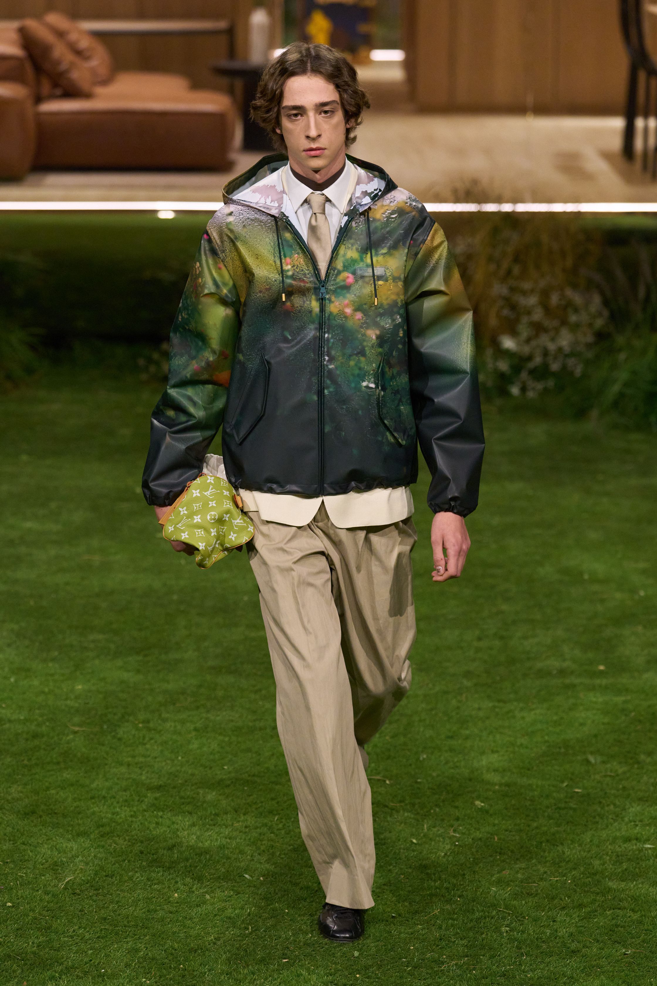 Louis Vuitton 26FW 男装以“当代绅士的旅行状态”为核心，在花园式场景中展开一场关于移动、身份与功能的叙事。功能夹克、细致西装、学院感针织与标志性包袋并行出现，色彩回归卡其、橄榄绿、灰褐与深红，呈现出低调却高度可穿的奢华现实主义。系列强化了“穿着中的生活感”，将品牌传统的旅行基因转译为更克制、更日常的现代衣橱方案-顽石频道趋势研究